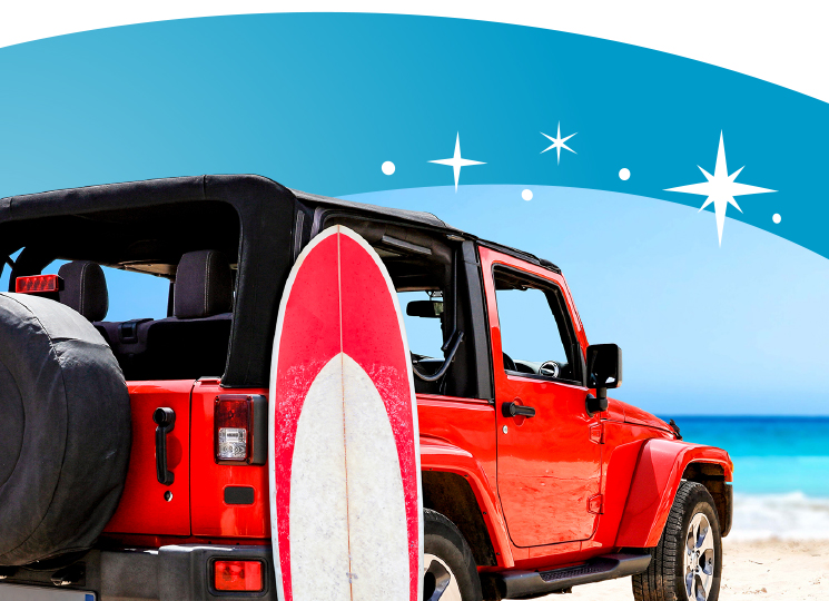 Jeep overlooking a beach with a surfboard next to it