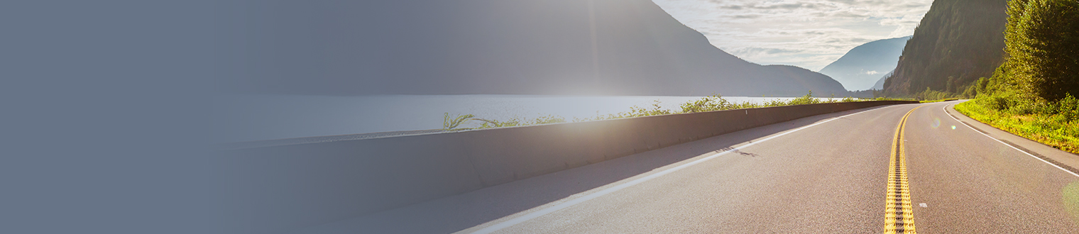 Road in between mountains and water