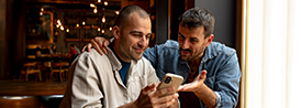 two men discussing while looking at a phone screen