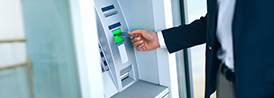 Man putting a plastic card on an ATM machine